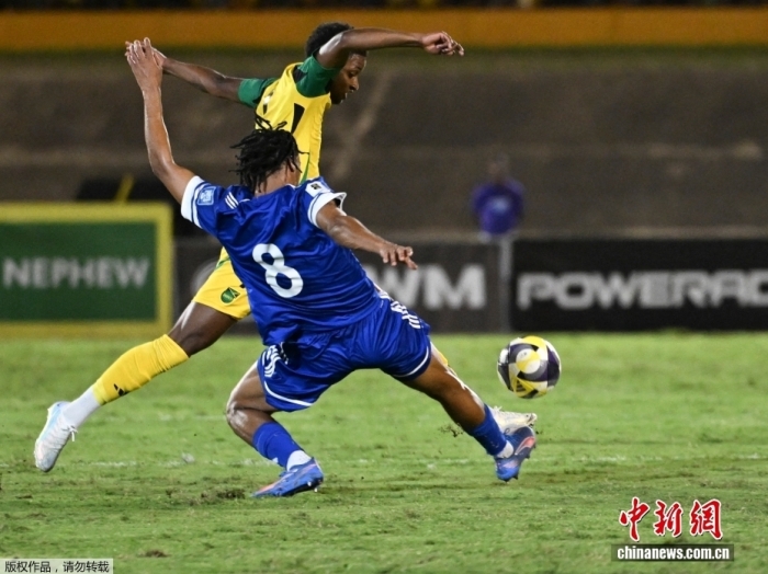 图为库拉索队球员(蓝衣)比赛中拼抢。 图为库拉索队球员(蓝衣)比赛中拼抢。